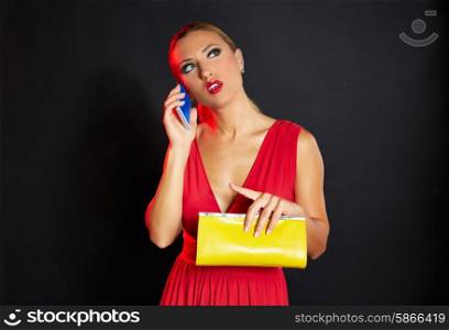 Blond fashion woman talking smartphone on black background and red dress