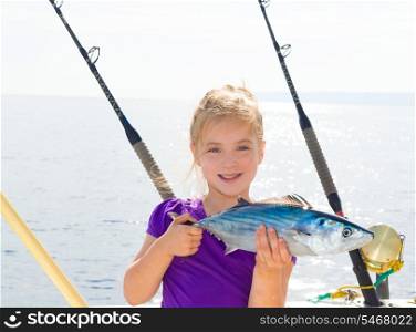 Blond girl fishing bonito Sarda tuna trolling in Mediterranean sea