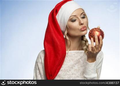 blond girl in white dress with a long christmas hat looking in cameara