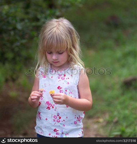 Blond Girl looking at a Flower at Moorea in Tahiti