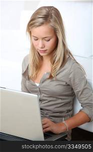 Blond girl sitting in sofa surfing on internet