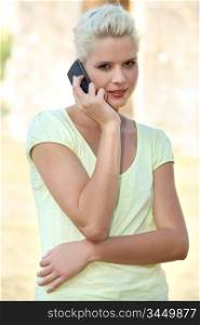 Blond girl using mobile telephone