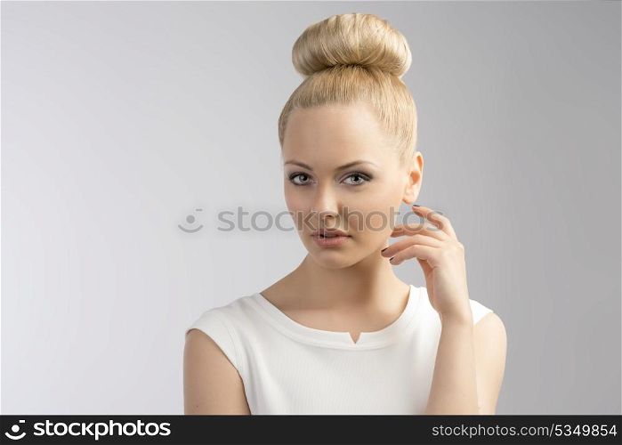 blond girl with white dress and up hair style looking in camera with sweet look