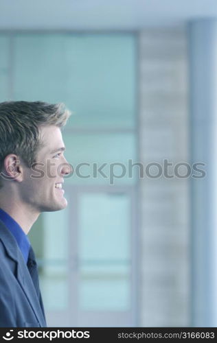 Blond hair blue eye businessman smiles as he looks forward