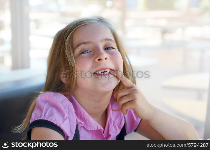 Blond happy kid girl showing her indented teeth portrait