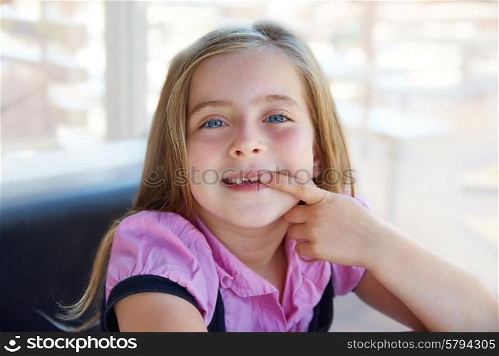 Blond happy kid girl showing her indented teeth portrait