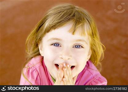 blond happy smiling little girl excited laugh hands in mouth