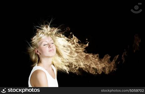 Blond in fire. Young attractive blond woman with hair in fire flames