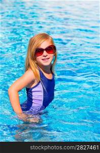 blond kid girl in blue pool posing with sunglasses smiling