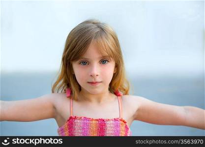Blond kid girl open arms in outdoor with sundress