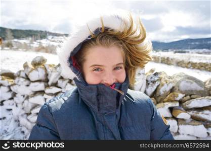 Blond kid girl playing with snow ball in winter