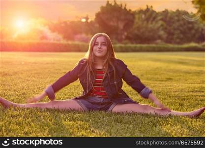 Blond kid girl splitting legs at sunset park outdoor
