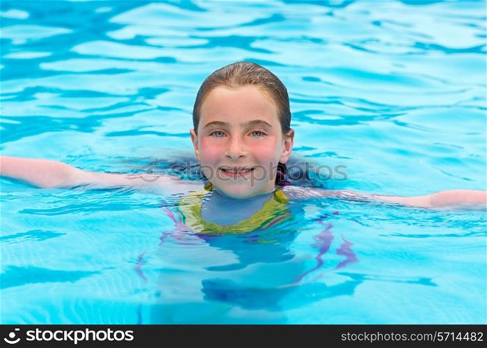 Blond kid girl swimming in the pool with sun tan red cheeks