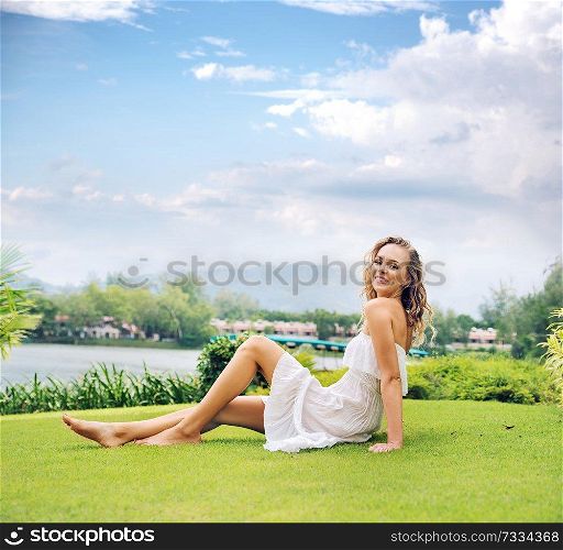 Blond lady resting on the fresh green lawn