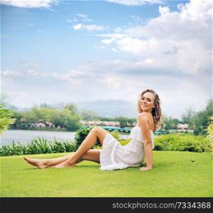Blond lady resting on the fresh green lawn