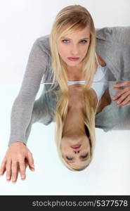 Blond leaning on reflective surface