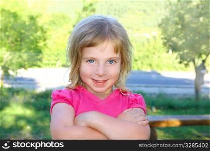 Blond little girl portratit happy smiling facing camera crossed arms