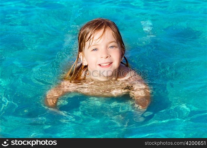 blond little girl swimming on turquoise beach in Ibiza