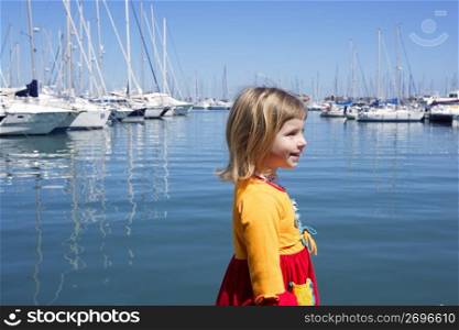 blond little girl walking in blue marina