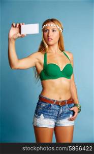 Blond long hair girl with jeans shorts selfie photo with smartphone on blue background
