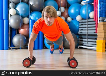 Blond man gym push-up strength pushup exercise with dumbbells workout