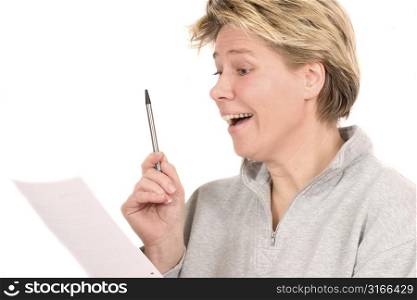 Blond mature woman looking at a document and looking as if she found the golden egg