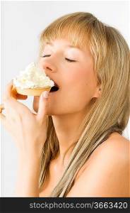 blond nice girl eating a dessert with a lot of cream