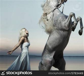 Blond nymph posing with the majestic horse