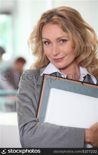 Blond office worker stood with folders