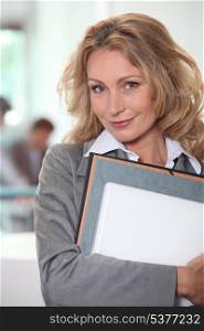 Blond office worker stood with folders