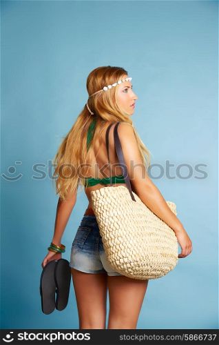 Blond sexy tourist girl with short jeans and basket bag and flip flop shoes going beach