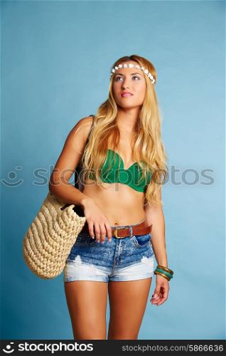 Blond sexy tourist girl with short jeans and basket bag on blue