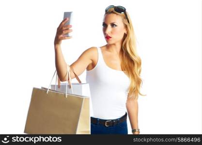 Blond shopaholic woman with bags selfie with smartphone on white background