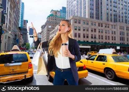 Blond shopping tourist girl calling a yellow Taxi in New York fifth avenue Photomount