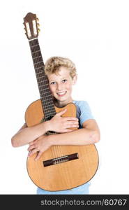blond teen boy in blue holds guitar in studio against white background