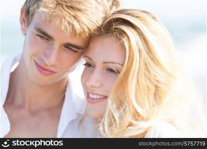 Blond teen couple hug together in beach outdoor at summer vacation