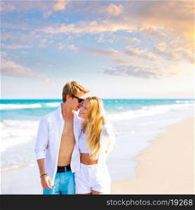 Blond teen couple walking together in the beach outdoor