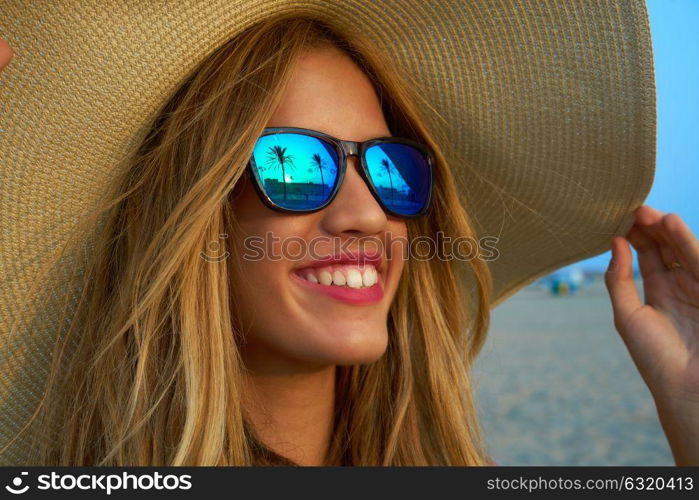 Blond teen girl sunglasses and pamela sun hat at palm tree sunset