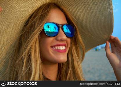 Blond teen girl sunglasses and pamela sun hat at palm tree sunset