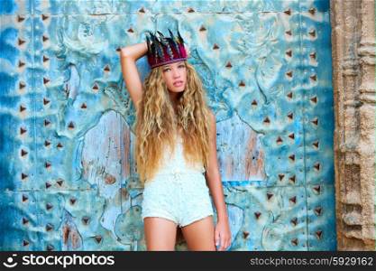 Blond teen girl tourist in Mediterranean old town door with colorful feathers on hair