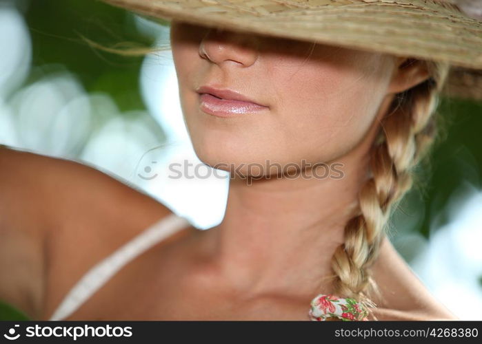 Blond teenage girl wearing hat covering eyes