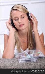 Blond teenager listening to music through headphones
