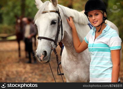 Blond teenager next to horse