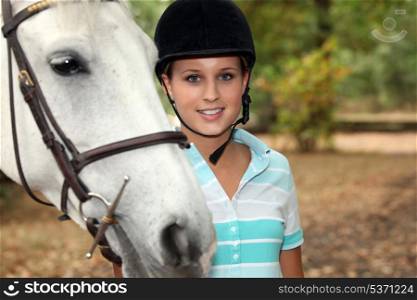 Blond teenager stood with horse