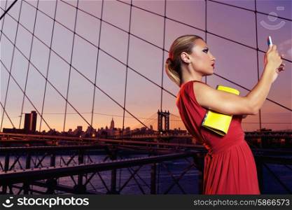 Blond tourist girl selfie photo in Brooklyn Bridge New York at night sunset Photomount