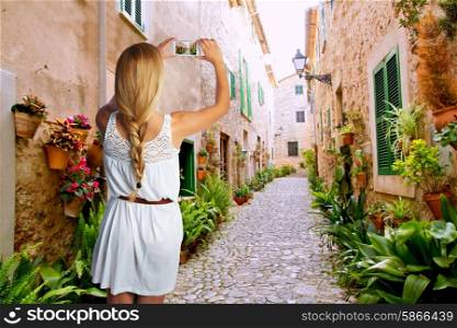 Blond tourist girl taking photos of Mallorca Valldemossa village street photomount