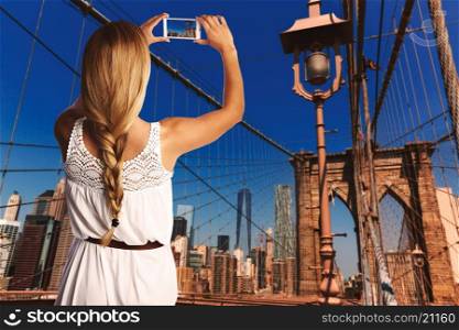 Blond tourist taking photo in Brooklyn bridge New York photomount