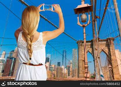 Blond tourist taking photo in Brooklyn bridge New York photomount