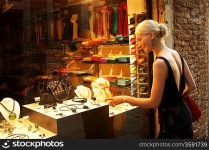 Blond woman against shop window.