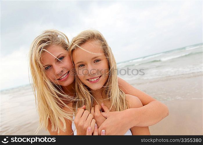 Blond woman and young girl on a sandy beach